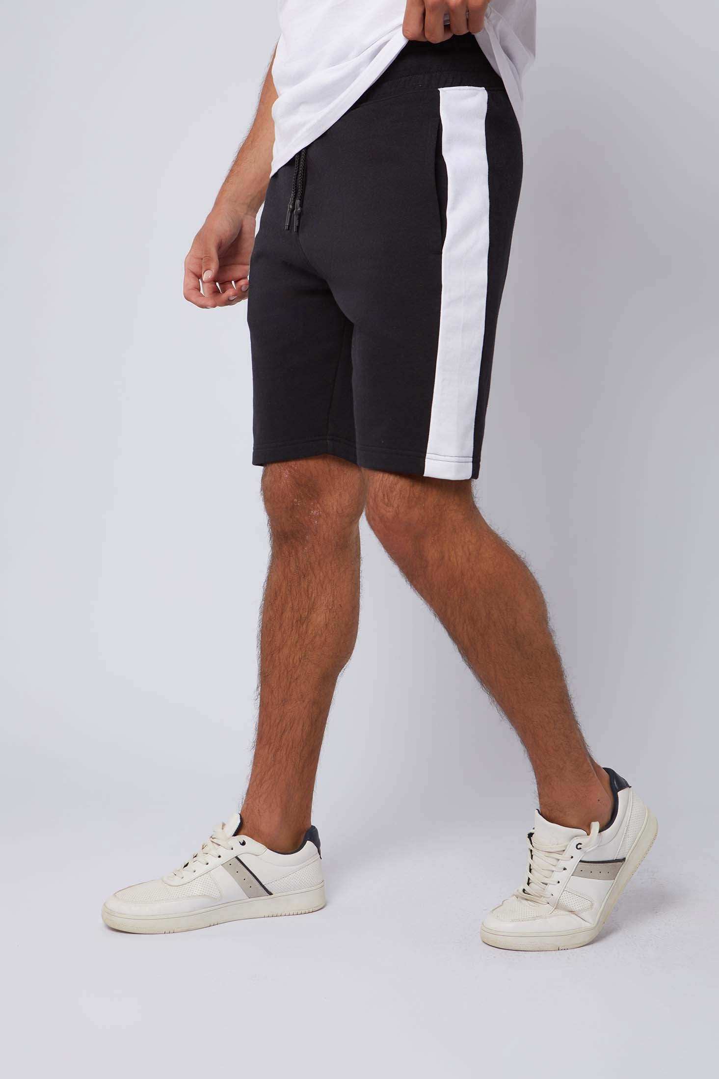 Men's black shorts with white side stripe, casual wear, styled with white sneakers