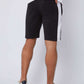 Men's black shorts with white side stripe, white sneakers, and white t-shirt, rear view