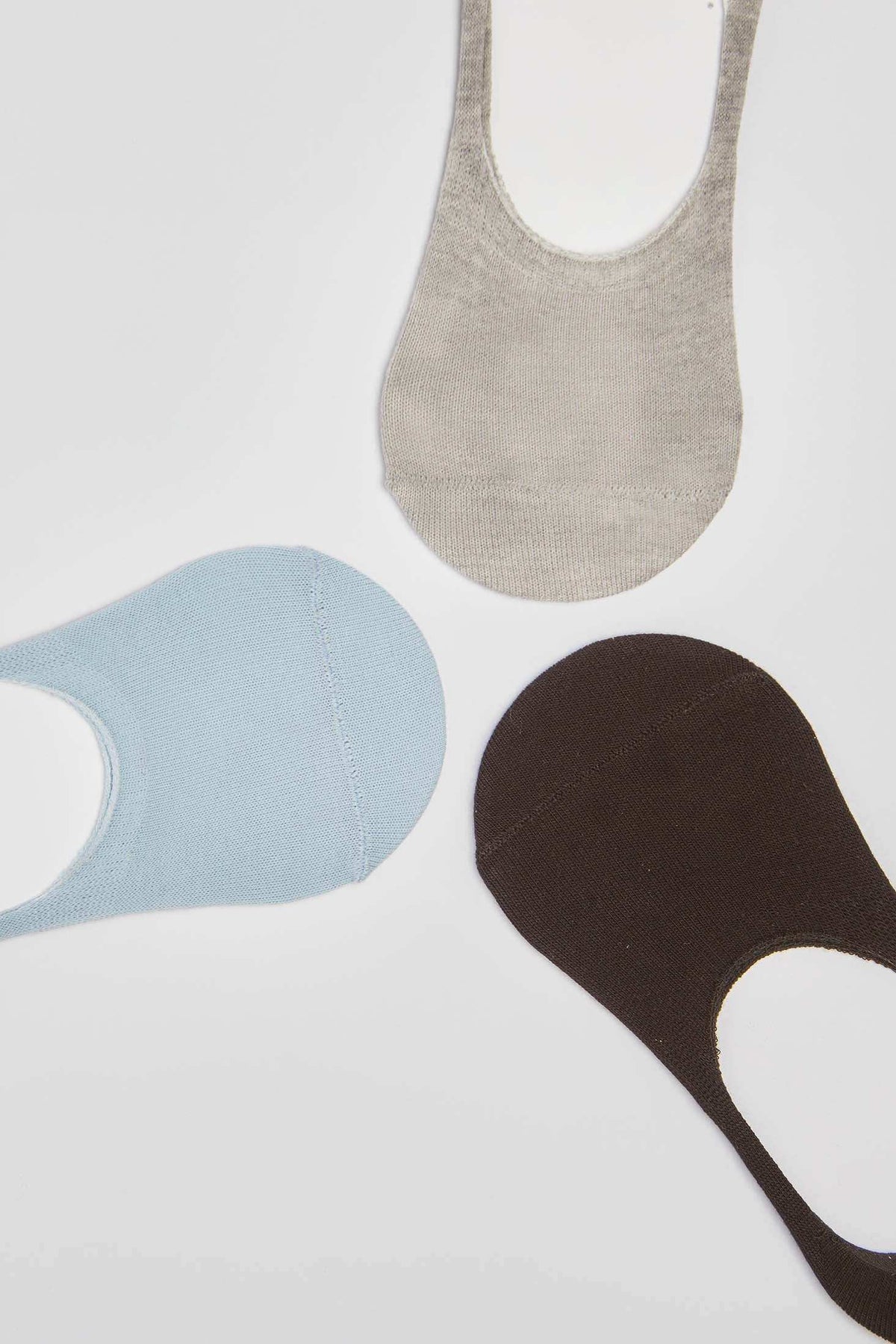Three pairs of no-show socks in beige, light blue, and brown on a white background