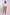 Woman wearing a white long sleeve blouse and coral pink pants, posing on a plain background