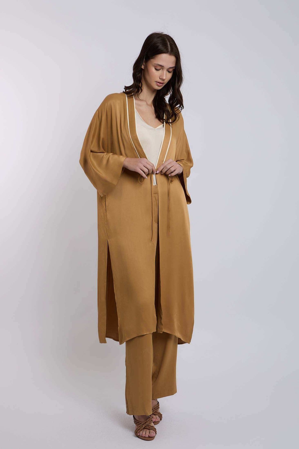 Woman in loose mustard yellow kimono jacket and pants set, neutral top, minimal style