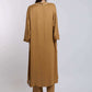 Woman wearing a loose camel brown long tunic top and matching pants, back view