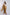 Woman wearing tan wide-leg pants, matching long coat, and cream blouse, fashion outfit