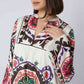 Woman wearing a white dress with colorful, bold geometric and floral patterns
