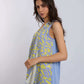 Woman wearing sleeveless abstract print blue and yellow top with blue pants