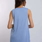 Woman wearing a sleeveless light blue top and blue pants, shown from the back.