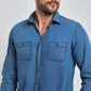 Man wearing a blue denim long-sleeve shirt with button front and chest pockets