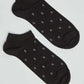 Black ankle socks with small white and red geometric dot pattern on plain background