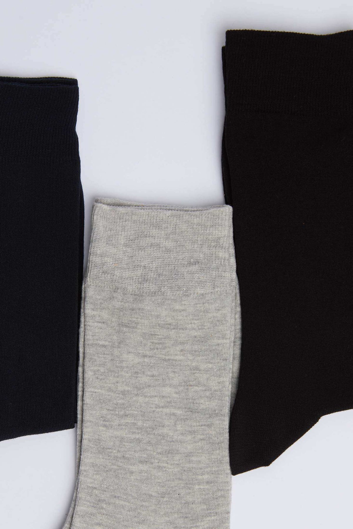 Set of three men's socks in black, grey, and dark navy on white background