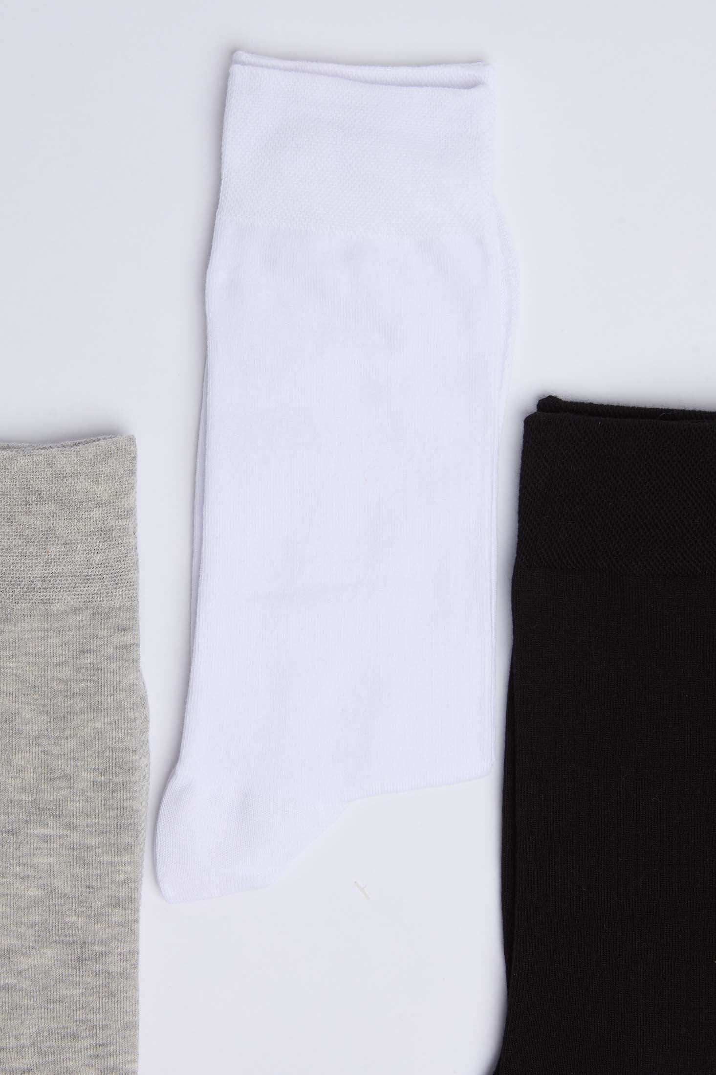 Three pairs of crew socks in grey, white, and black on a white background