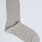 Single light grey cotton sock on plain background, casual men's or women's wear