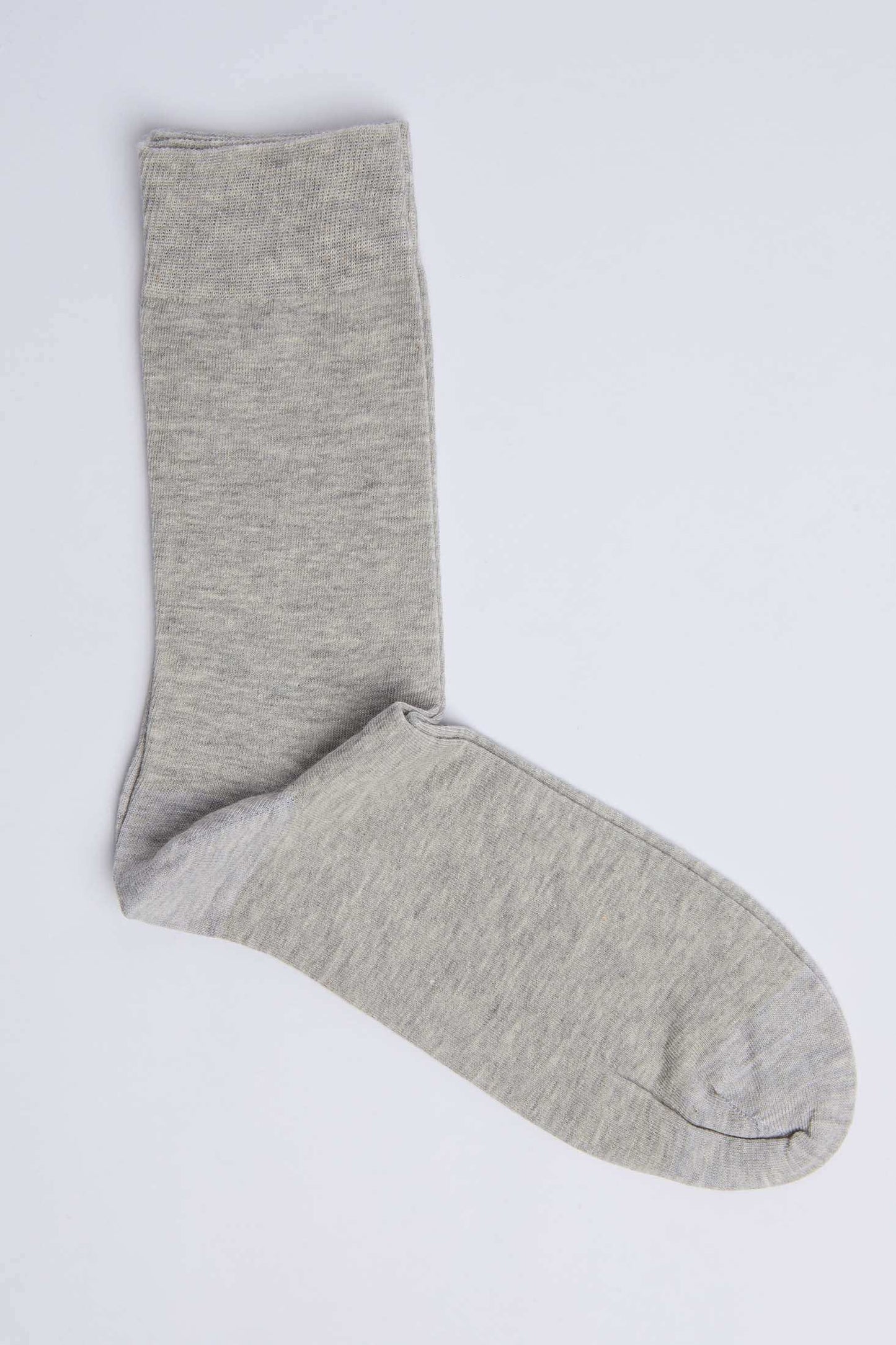 Single light grey cotton sock on plain background, casual men's or women's wear