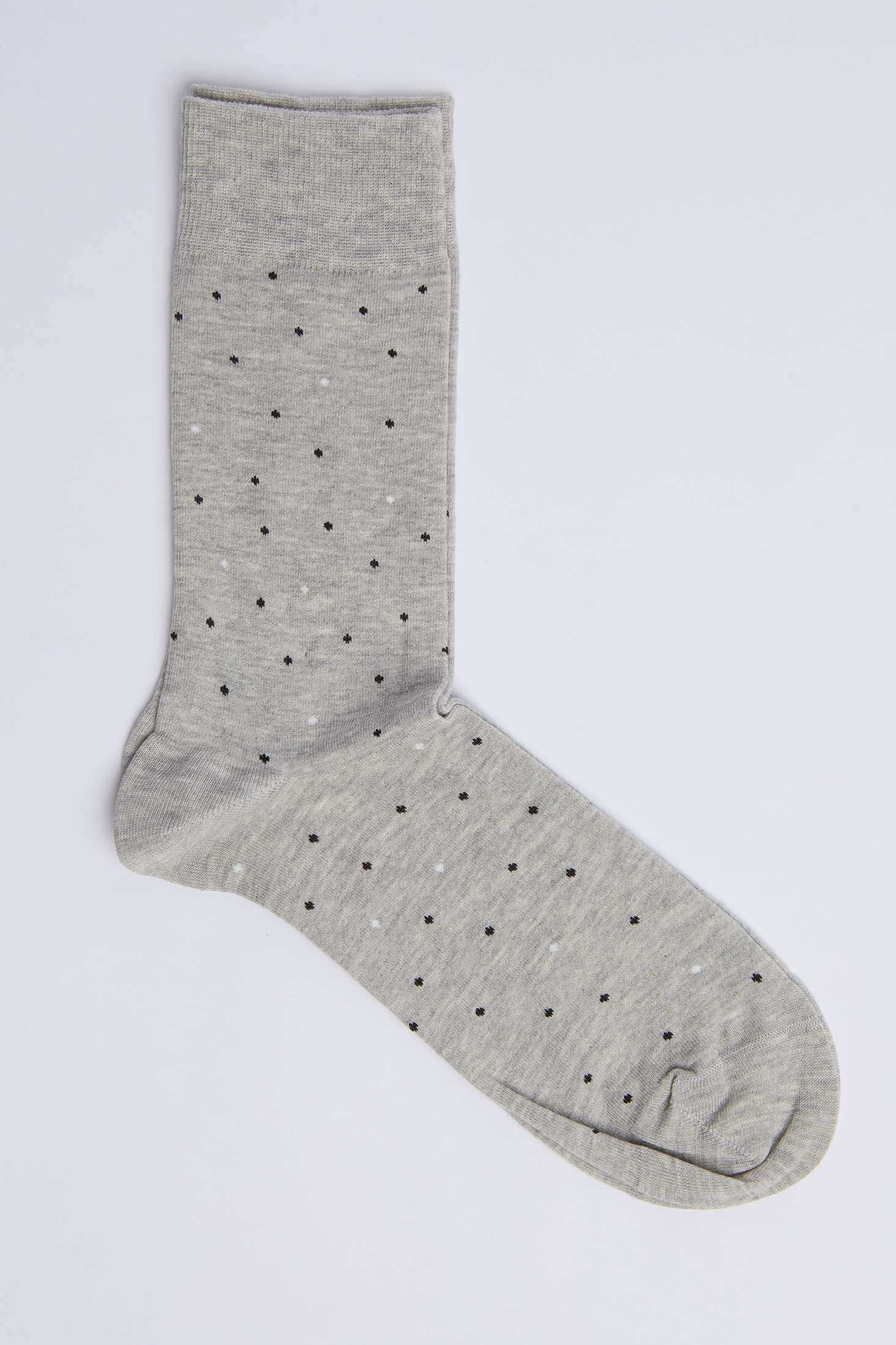 Grey dress sock with small black and white polka dots on a plain background