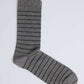 Gray crew sock with thin black horizontal stripes on white background