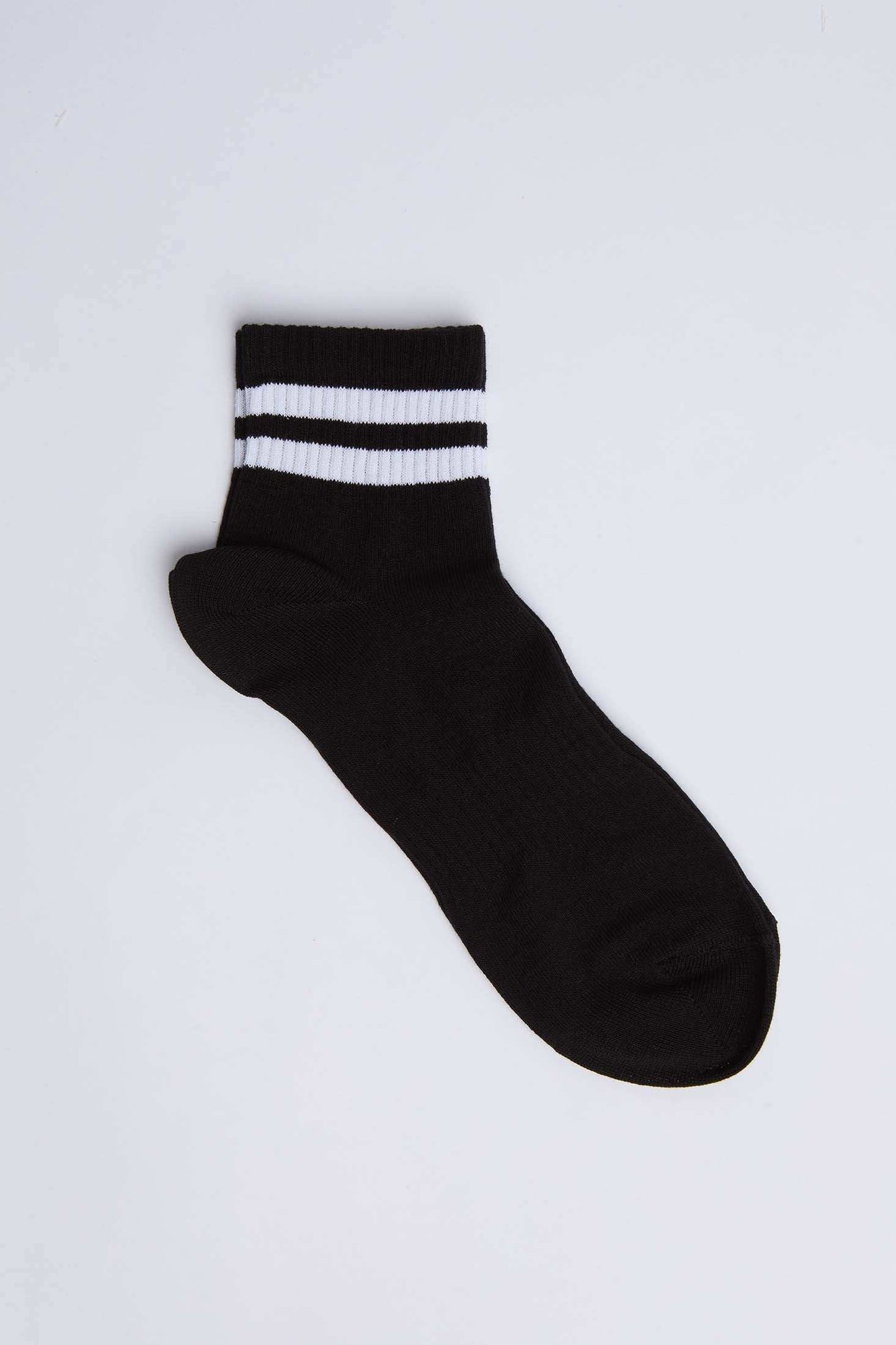 Black ankle sock with two white stripes, unisex casual wear, on white background