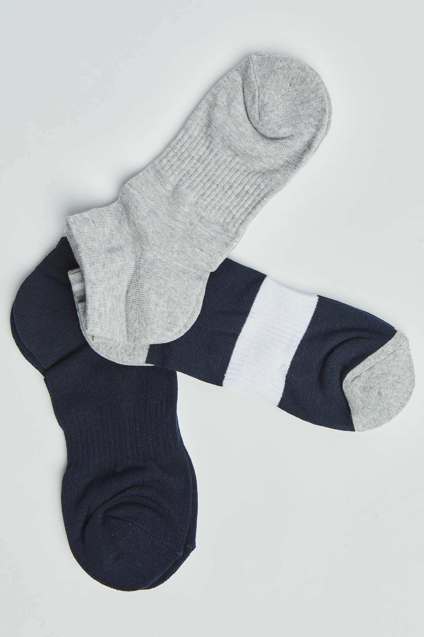 Set of three pairs of socks in grey, navy, and navy with a white stripe on a plain background