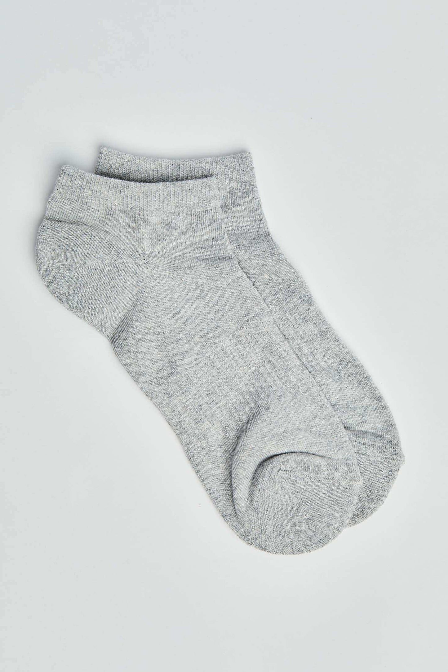 Pair of light grey ankle socks on a plain background, casual cotton blend socks
