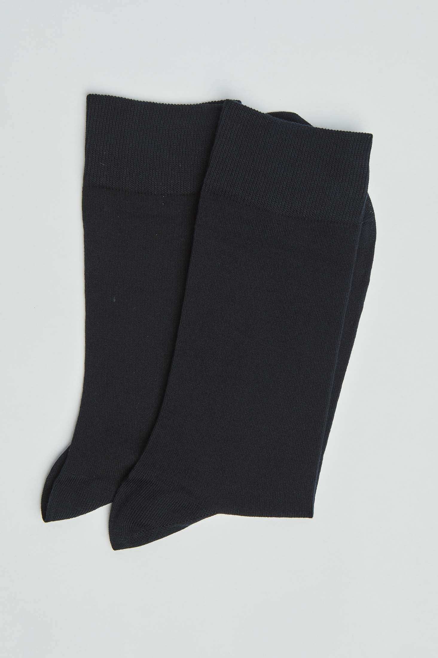 Pair of plain black men's dress socks on a light background