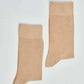 Pair of beige crew socks on white background, casual men's or women's socks