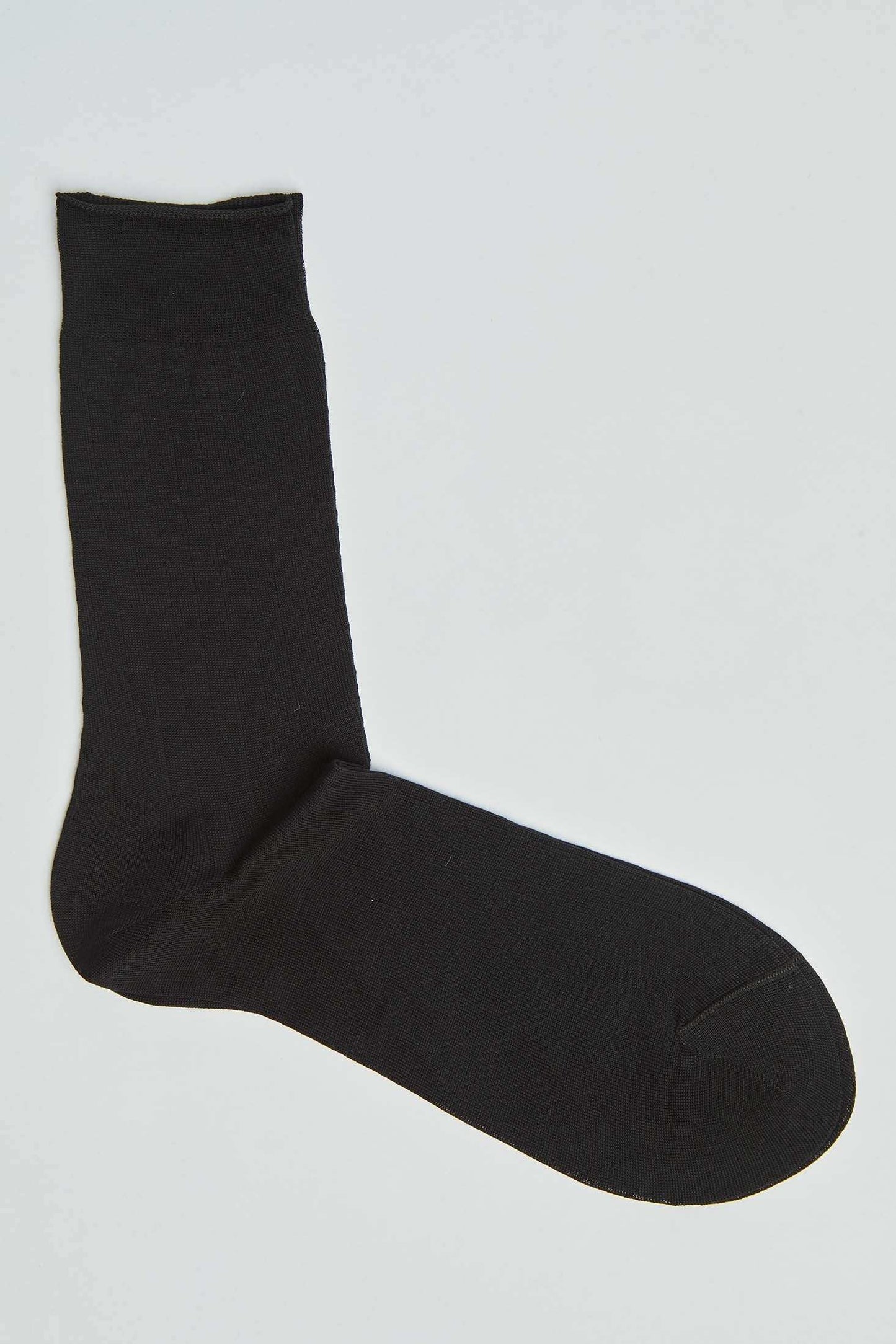 Classic black crew sock for men and women on a plain background