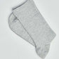 Pair of plain light grey crew socks on a white background