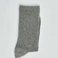 Gray ribbed crew sock folded on white background, casual men's or women's wear accessory