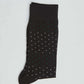 Black dress sock with small white and green polka dots on a light background