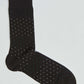 Black dress sock with white and green dot pattern on a light background