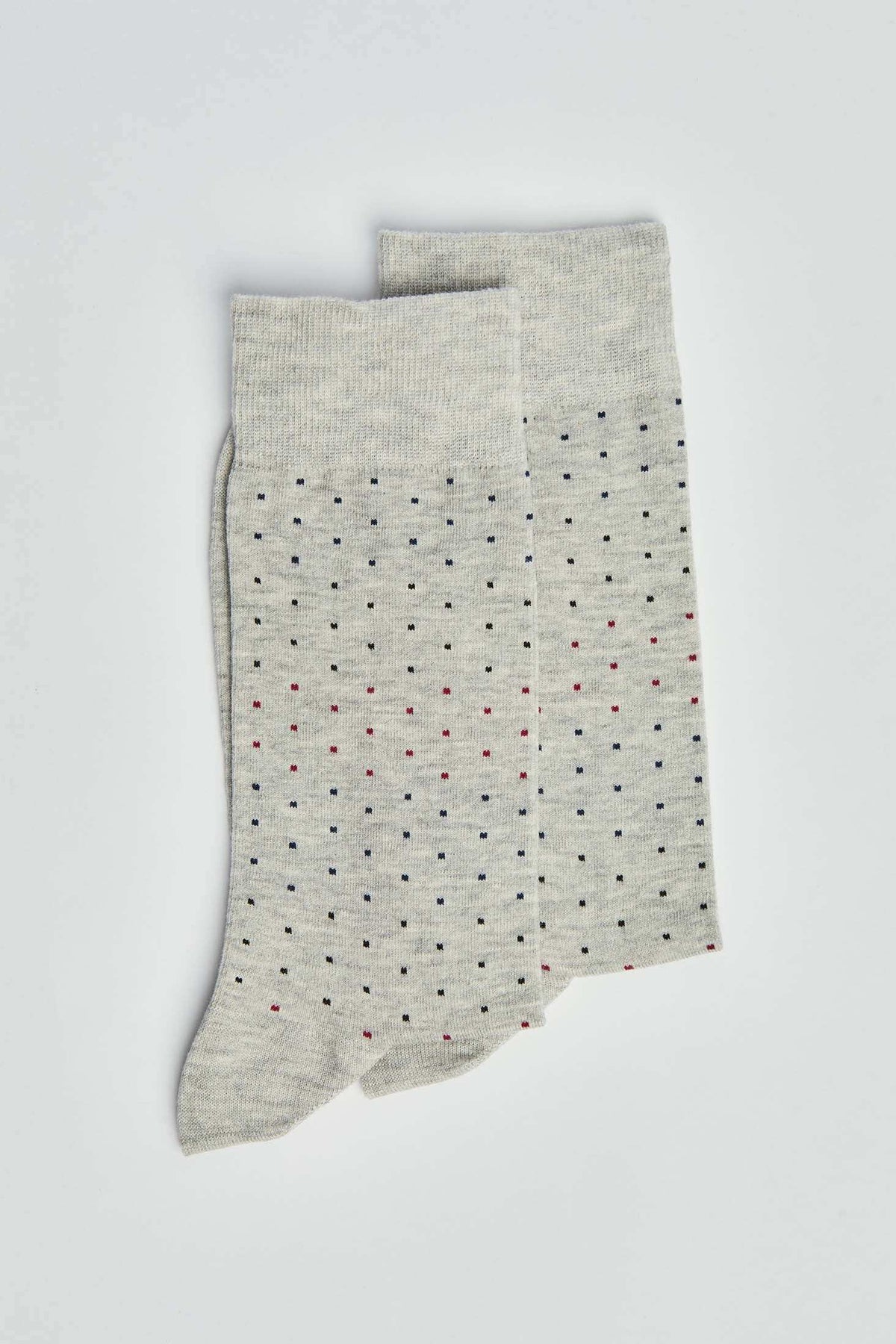 Light grey socks with small multicolored dotted pattern on a plain background