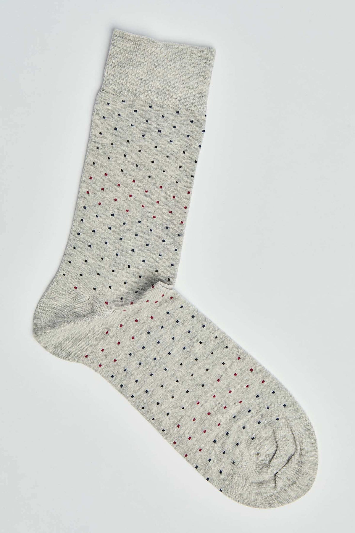 Light grey crew sock with small red, navy, and black polka dots on a white background
