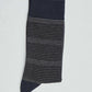 Navy blue sock with thin white and grey stripes, folded on a plain light background