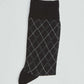 Black argyle sock with white diamond pattern on a plain background
