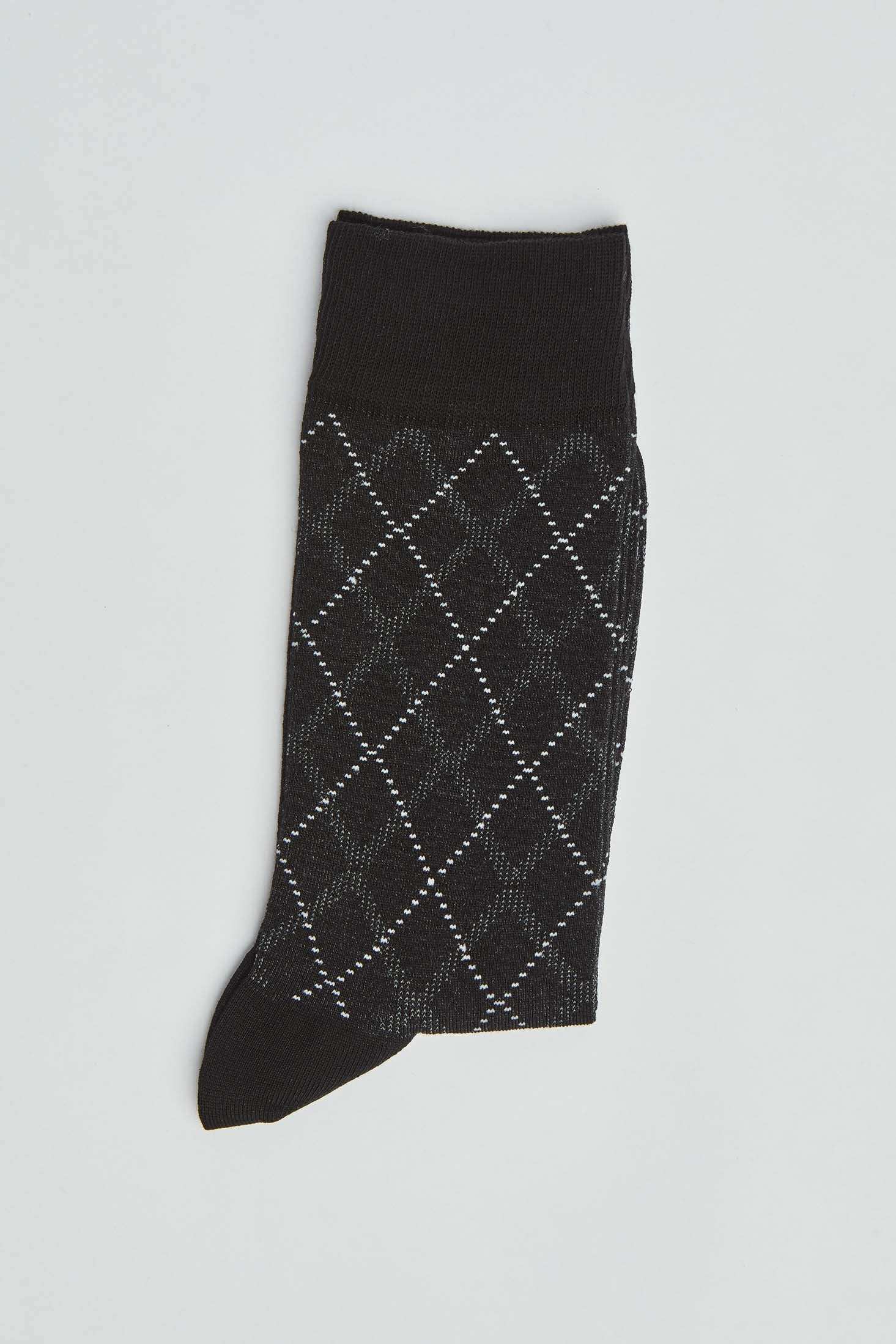 Black argyle sock with white diamond pattern on a plain background