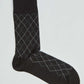 Black argyle patterned men's dress sock on a plain background