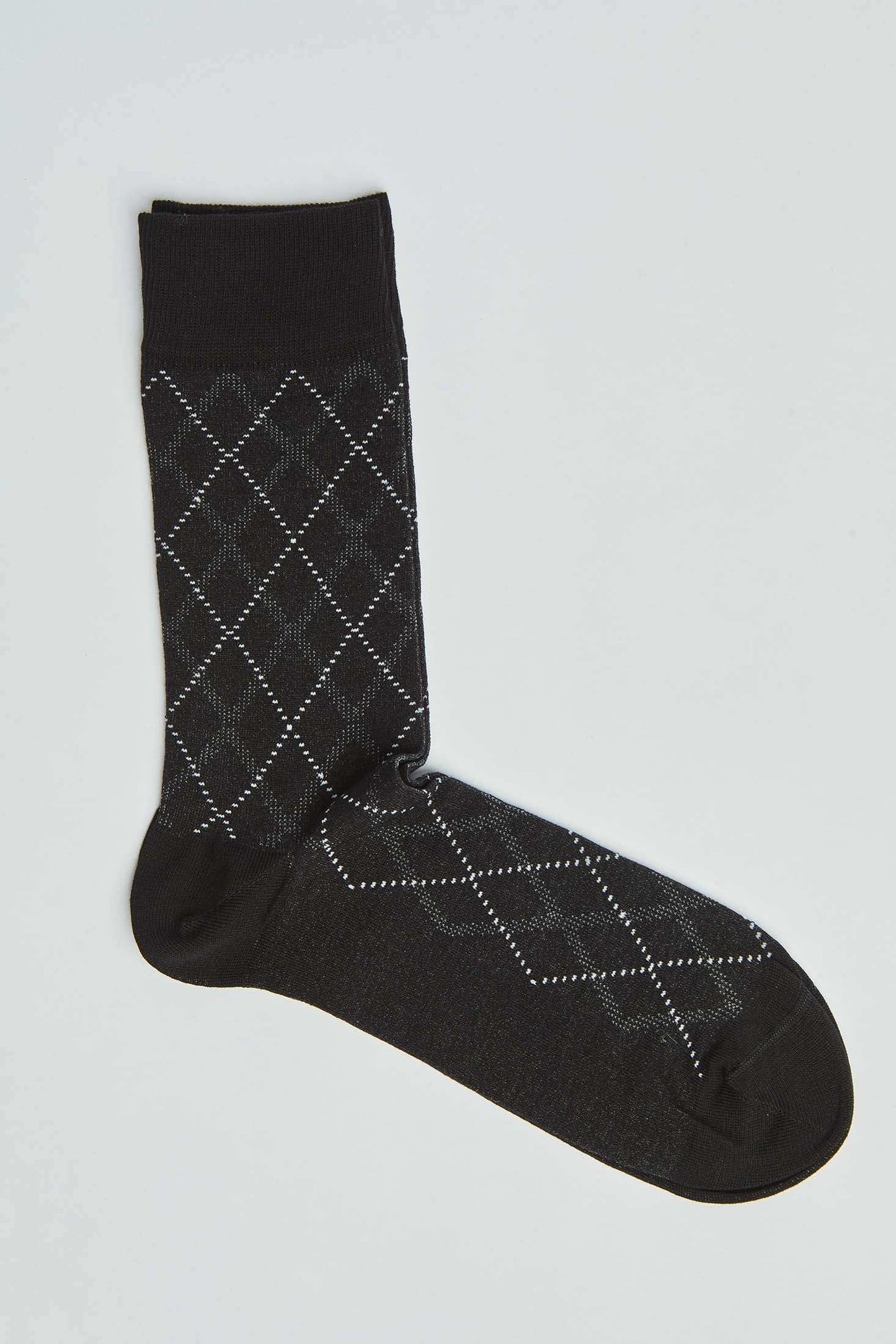 Black argyle patterned men's dress sock on a plain background