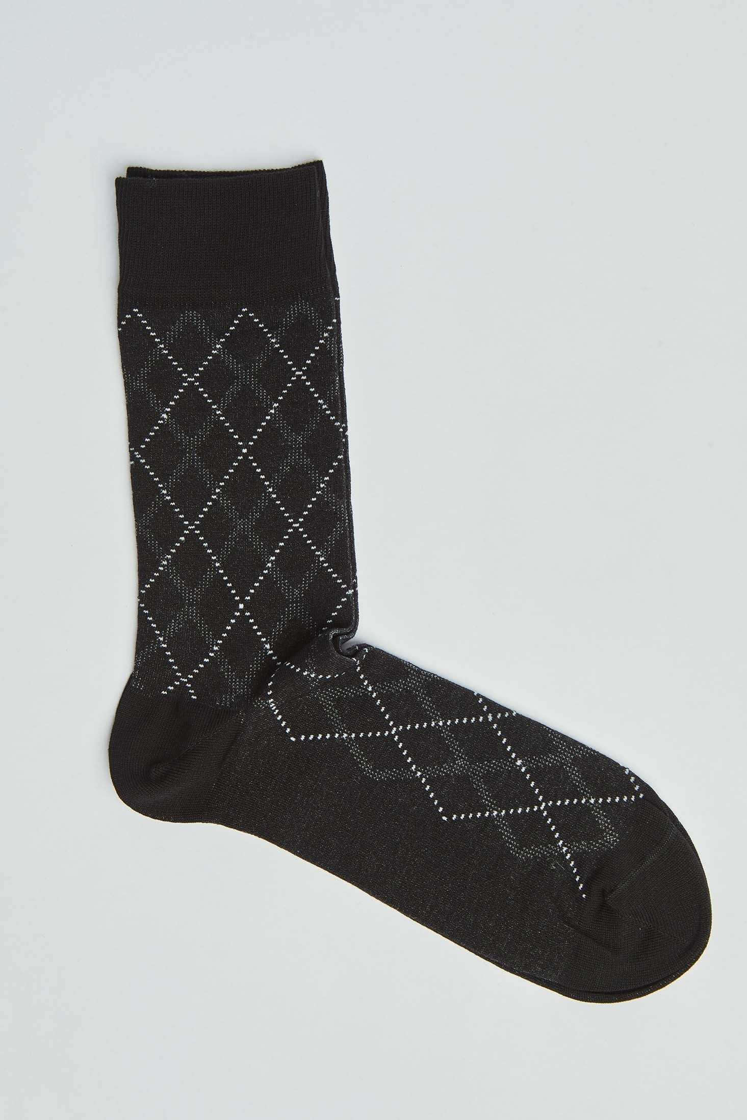 Black argyle patterned men's dress sock on a plain background