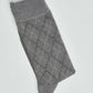 Folded grey argyle socks with a diamond pattern on a white background