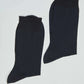Pair of plain black ribbed crew socks for men or women on white background