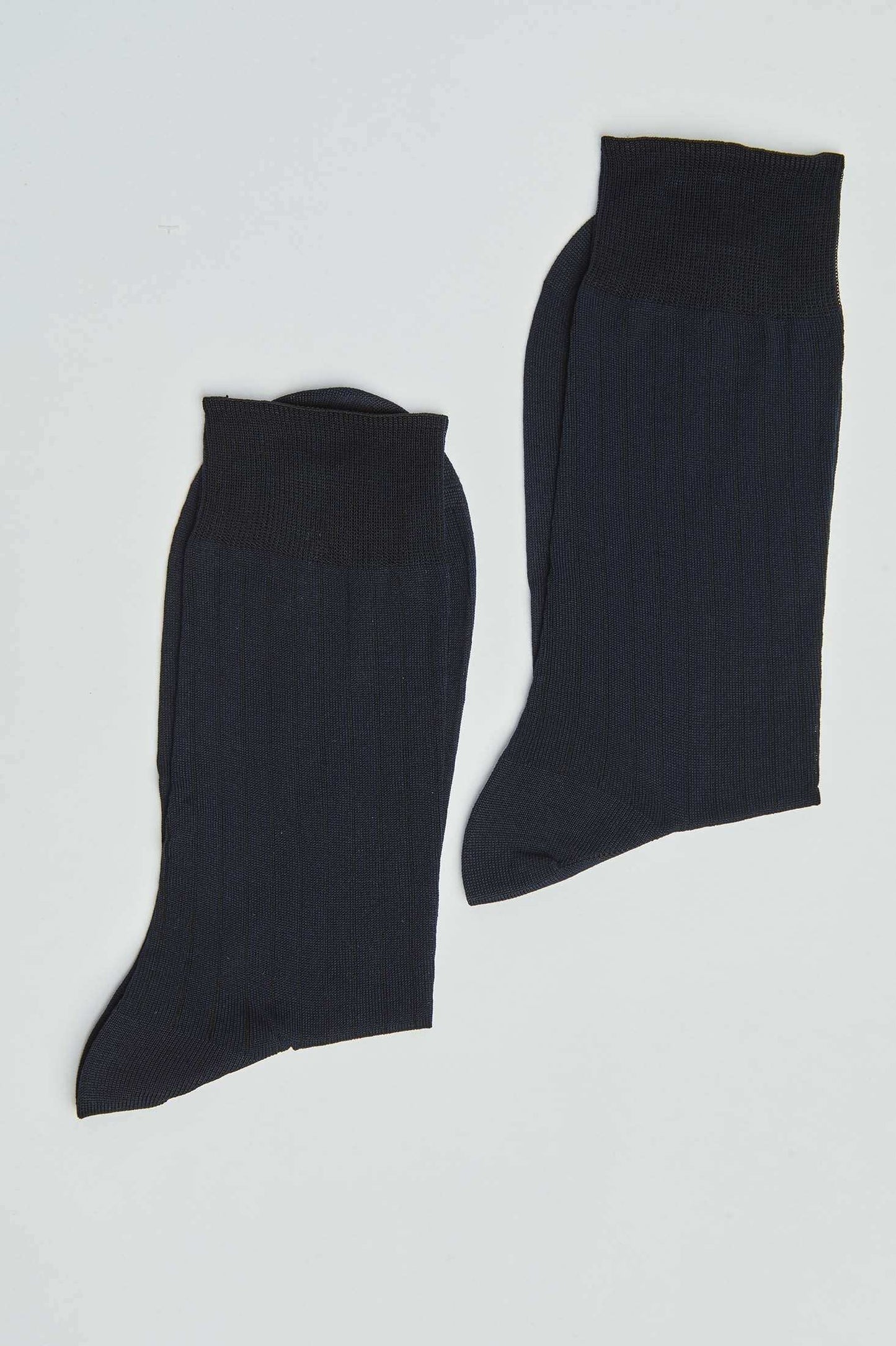 Pair of plain black ribbed crew socks for men or women on white background