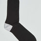 Black dress sock with contrasting white heel, flat lay on white background