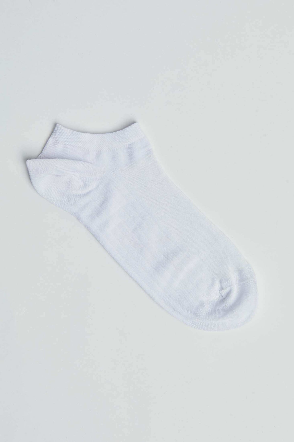 White ankle sock on plain background, casual unisex footwear, minimalist style