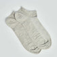 Pair of light grey ankle socks with subtle ribbed pattern on a white background