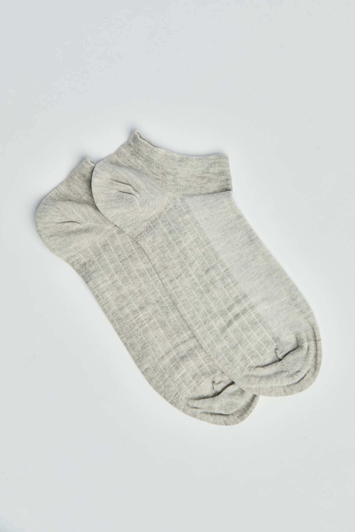 Pair of light grey ankle socks with subtle ribbed pattern on a white background