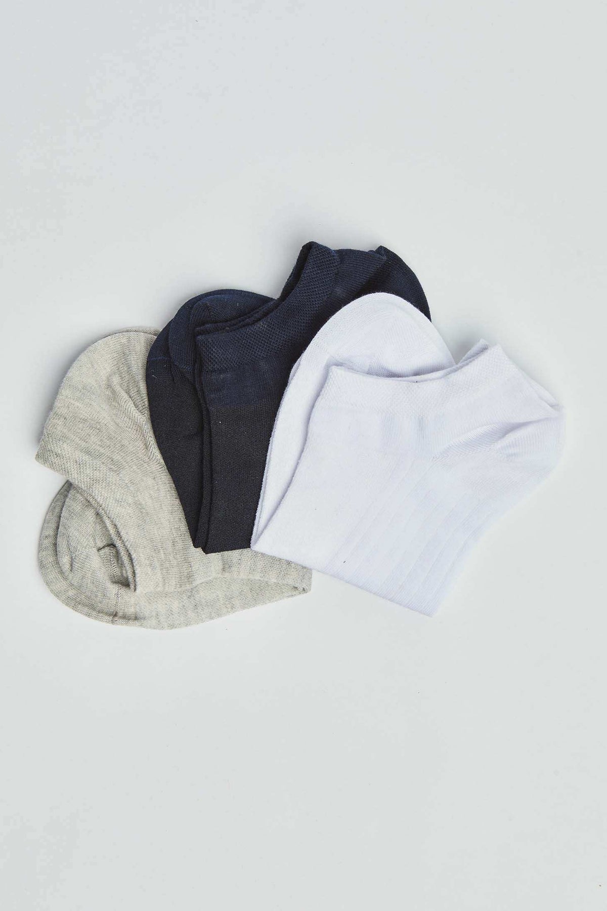 Set of low-cut socks in white, black, and grey on a plain background