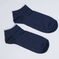 Pair of navy blue ankle socks with white polka dots on a white background