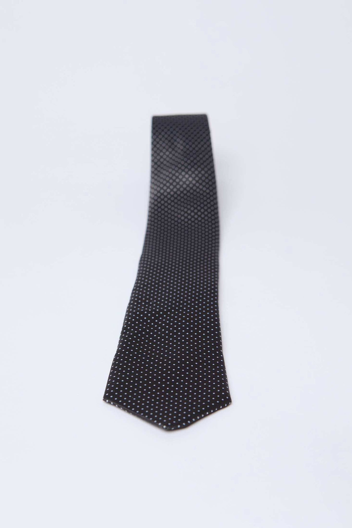 Dalydress men's black tie with small white polka dots on a plain background