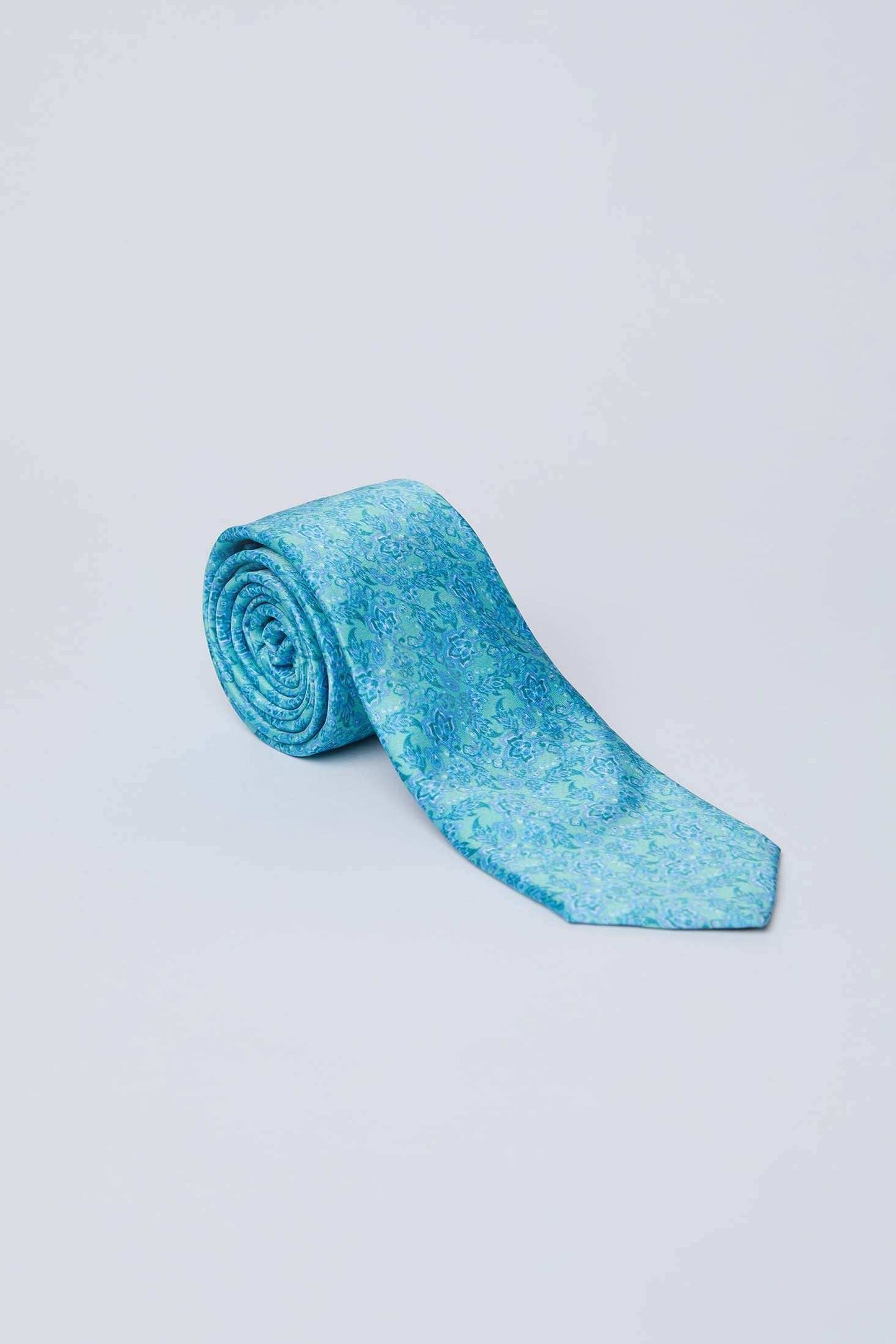Light blue paisley men's tie from Dalydress, rolled on a plain white background