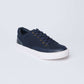 Navy blue casual sneaker with white sole and gold eyelets on a plain background