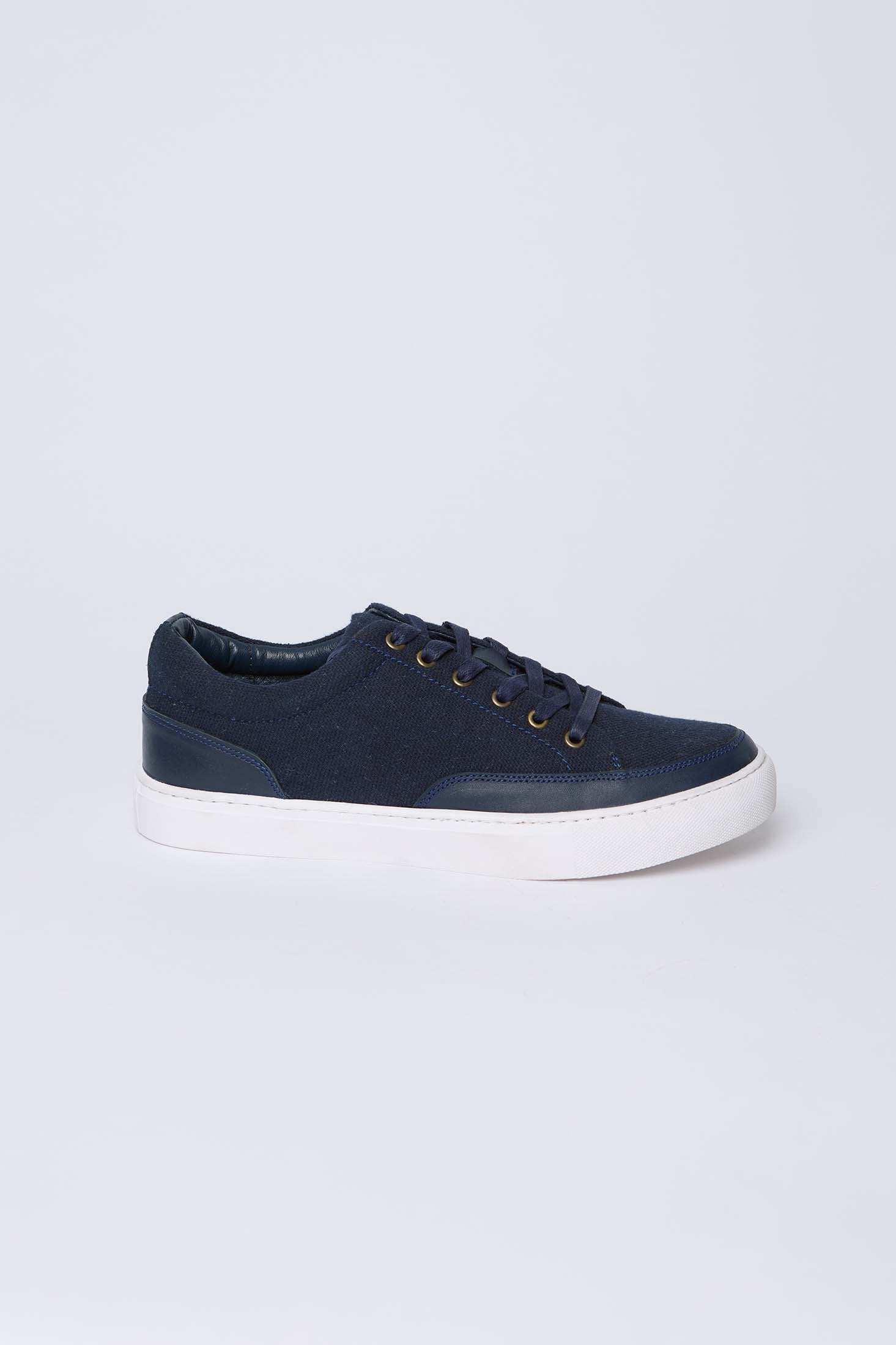 Men's navy blue casual sneaker with white sole, side view on plain background