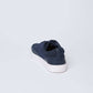 Navy blue men's casual sneaker with white sole on light background, rear angle view